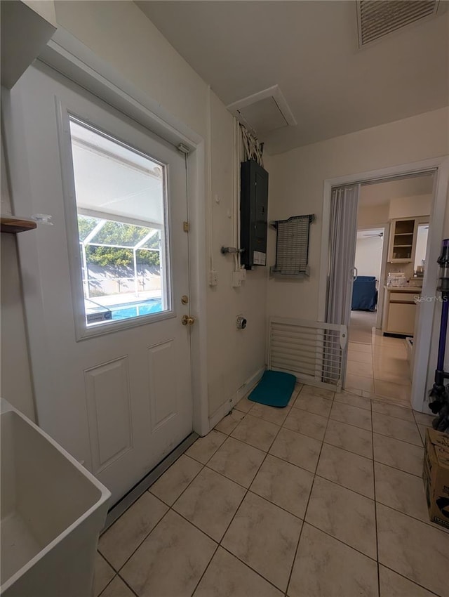 laundry room featuring light tile patterned flooring, visible vents, and electric panel