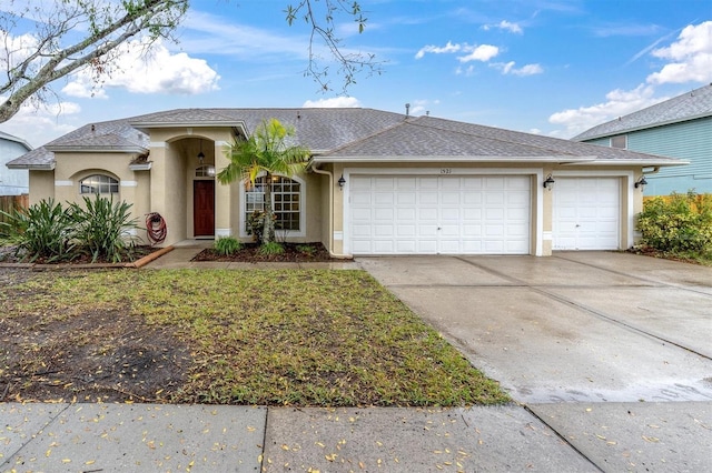 view of front of home featuring driveway, an attached garage, and stucco siding