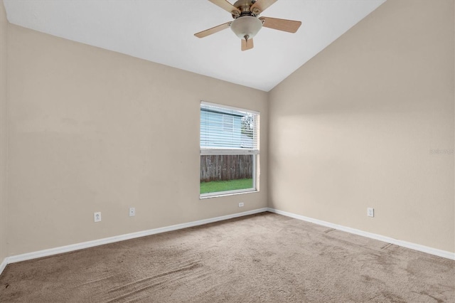 carpeted spare room with lofted ceiling, ceiling fan, and baseboards