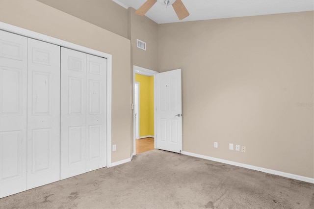 unfurnished bedroom with baseboards, visible vents, a ceiling fan, carpet, and a closet