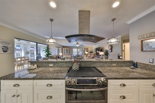 kitchen featuring range with two ovens, dark stone counters, ornamental molding, and island range hood