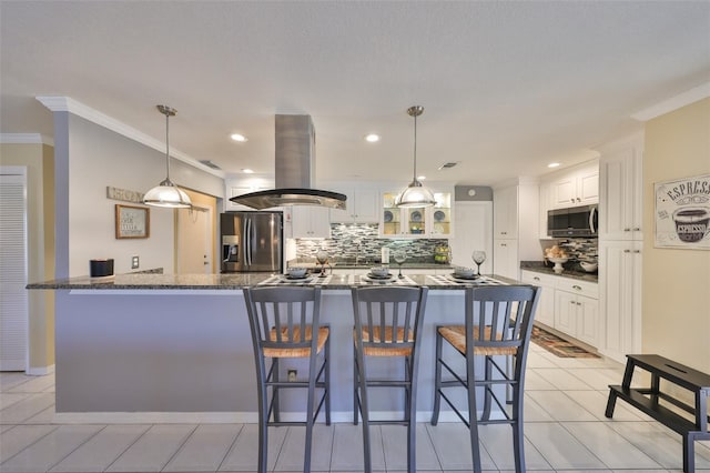 kitchen with island range hood, white cabinets, a breakfast bar area, glass insert cabinets, and stainless steel appliances