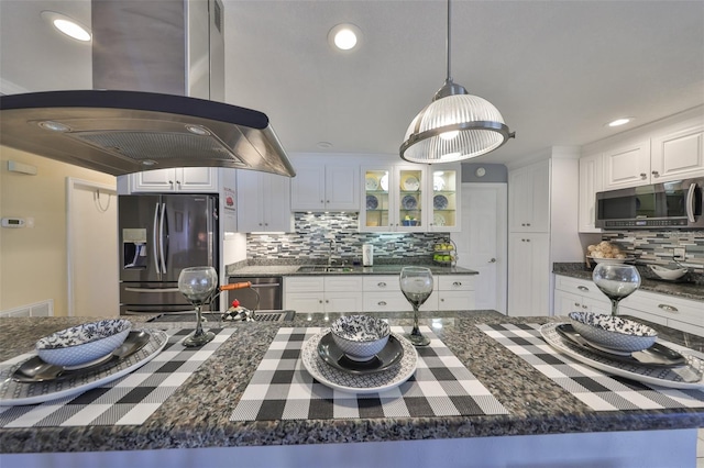 kitchen featuring island range hood, stainless steel appliances, a sink, white cabinetry, and glass insert cabinets