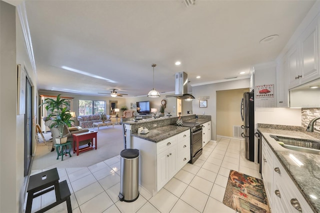 kitchen featuring range with two ovens, freestanding refrigerator, white cabinets, a sink, and island range hood