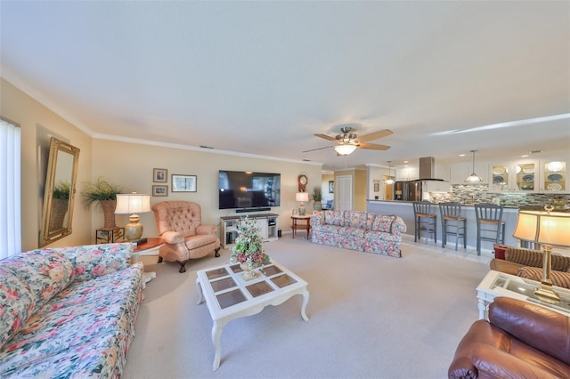 carpeted living room with ceiling fan and ornamental molding