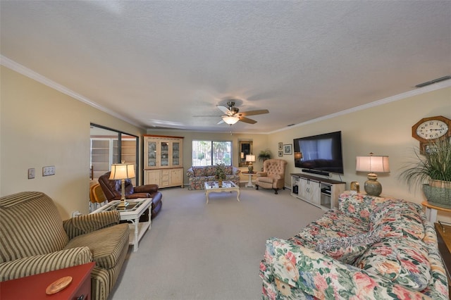 carpeted living room featuring ornamental molding, visible vents, a textured ceiling, and a ceiling fan