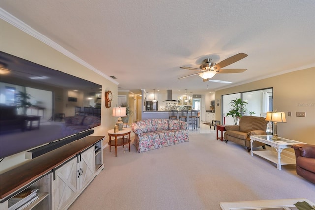 living area featuring a ceiling fan, ornamental molding, a textured ceiling, and light colored carpet