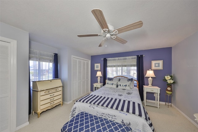 carpeted bedroom featuring ceiling fan, multiple windows, and baseboards