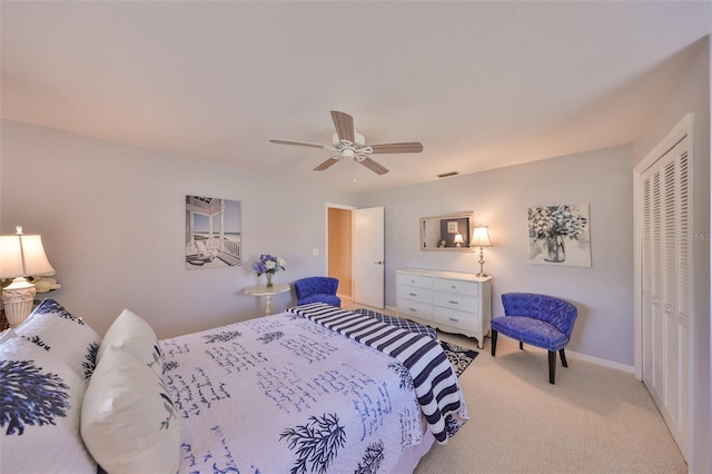 bedroom with a ceiling fan, a closet, light colored carpet, and baseboards