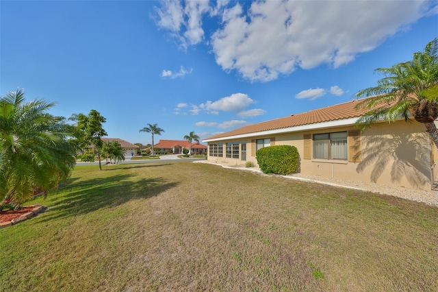 rear view of house with a lawn and stucco siding