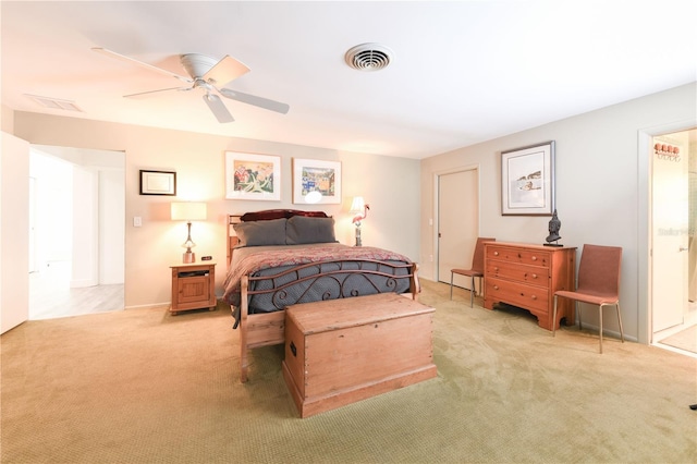 bedroom with carpet floors, visible vents, ensuite bathroom, and a ceiling fan