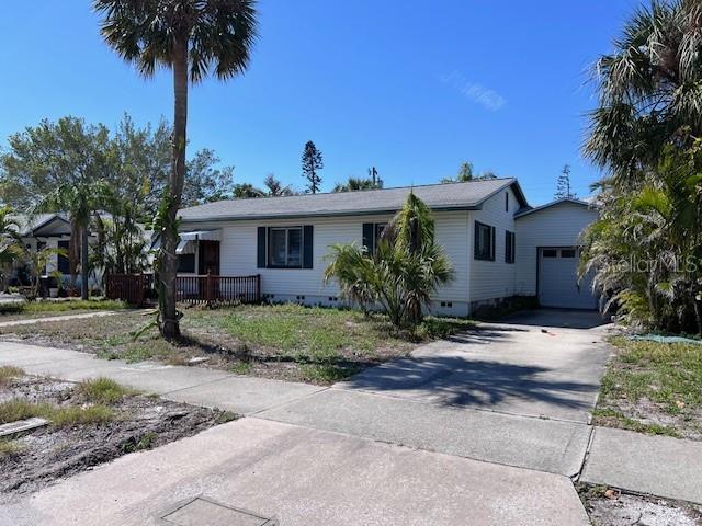 view of front of home with driveway, crawl space, an attached garage, and an outdoor structure