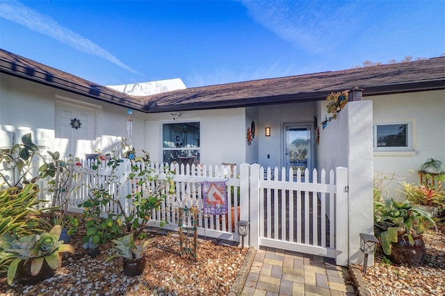 property entrance with fence and stucco siding