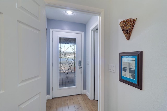 entryway with light wood-style flooring and baseboards