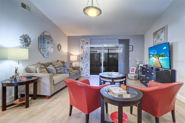 living area with visible vents, light wood-style flooring, and baseboards