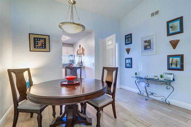 dining space with light wood-style floors, baseboards, and visible vents