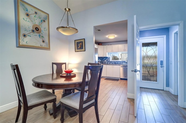 dining room with wood finish floors, visible vents, and baseboards