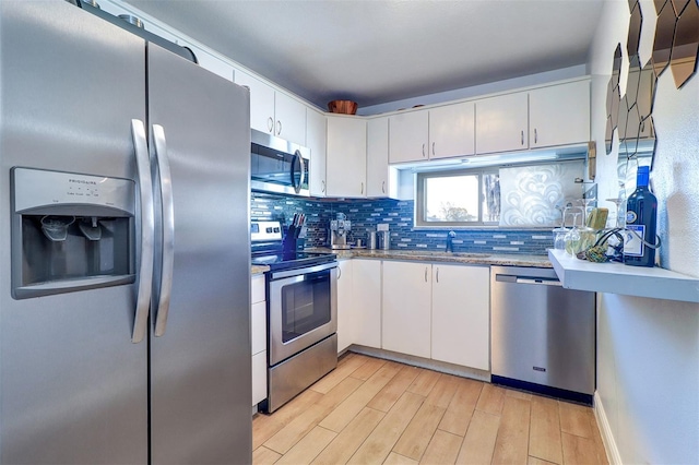 kitchen with decorative backsplash, appliances with stainless steel finishes, light wood-style floors, white cabinets, and a sink