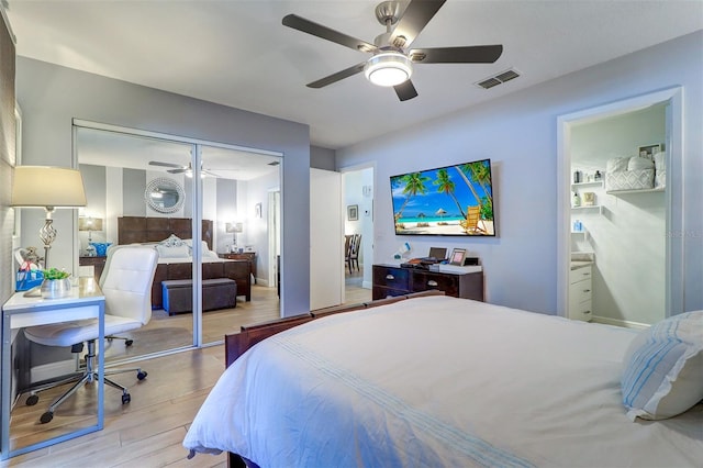 bedroom featuring a ceiling fan, a closet, visible vents, and wood finished floors