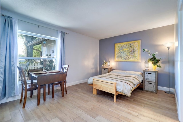 bedroom with light wood-style flooring and baseboards