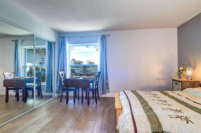 bedroom with a closet, light wood-style flooring, and baseboards