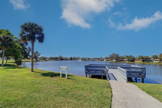 view of dock featuring a lawn and a water view