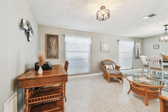 sitting room featuring visible vents, a textured ceiling, baseboards, and speckled floor