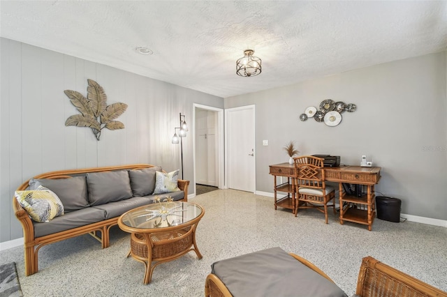 living room with baseboards, a textured ceiling, and speckled floor