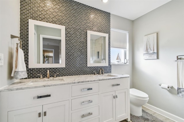 full bathroom featuring toilet, decorative backsplash, and a sink