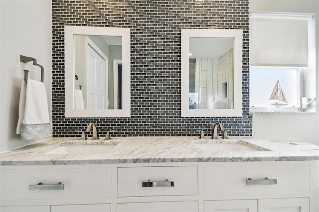 full bath featuring double vanity, tasteful backsplash, and a sink