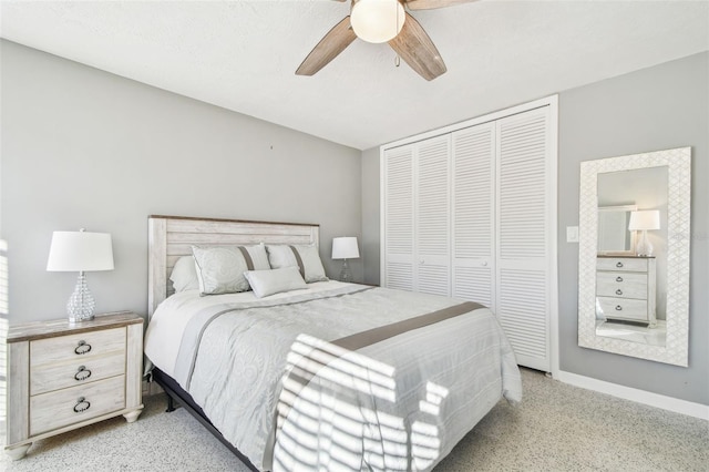 bedroom with light speckled floor, a closet, ceiling fan, and baseboards