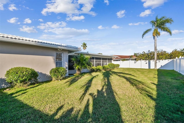 view of yard featuring a sunroom and a fenced backyard