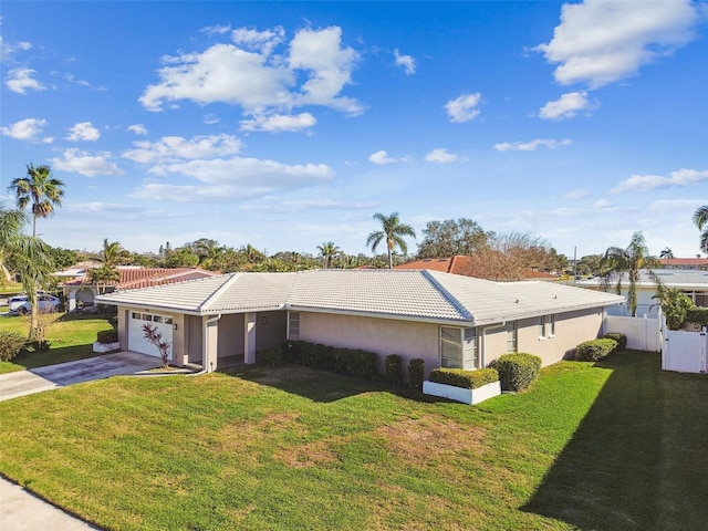 view of property exterior featuring a garage, a tile roof, concrete driveway, and a yard