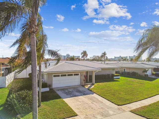 ranch-style house with fence, a garage, driveway, a tiled roof, and a front lawn