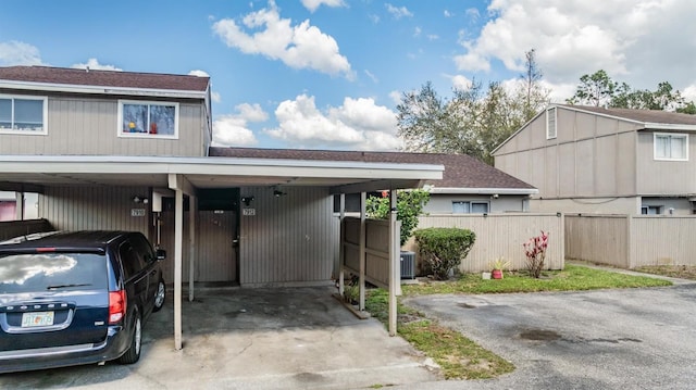 exterior space featuring roof with shingles, fence, and central air condition unit