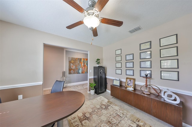 office space featuring light tile patterned floors, a textured ceiling, visible vents, and baseboards