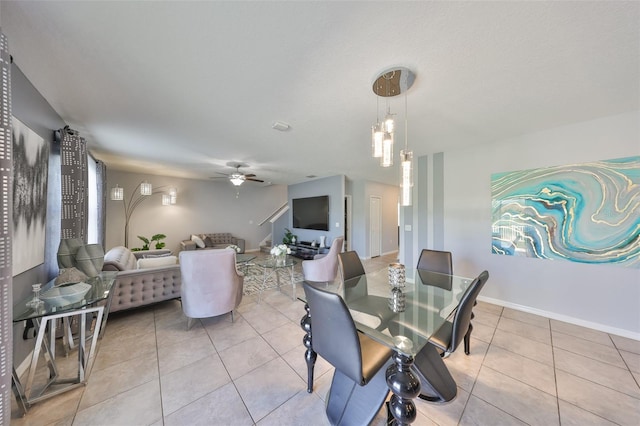 dining area featuring a ceiling fan, baseboards, and light tile patterned floors