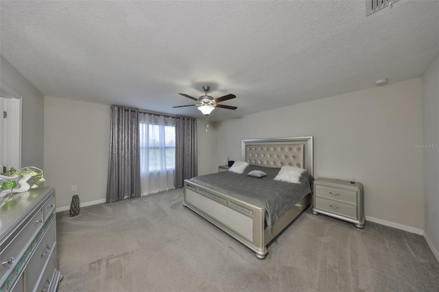 bedroom featuring baseboards, visible vents, ceiling fan, a textured ceiling, and carpet flooring