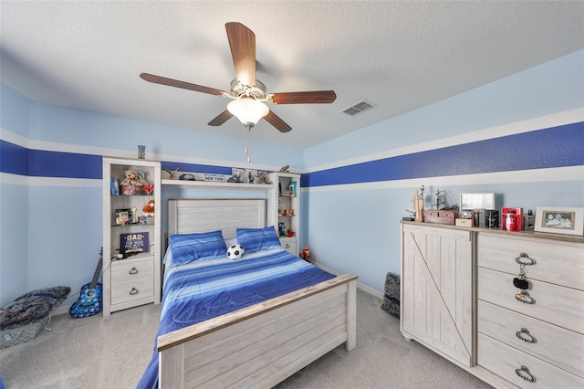 bedroom with a textured ceiling, ceiling fan, carpet, and visible vents