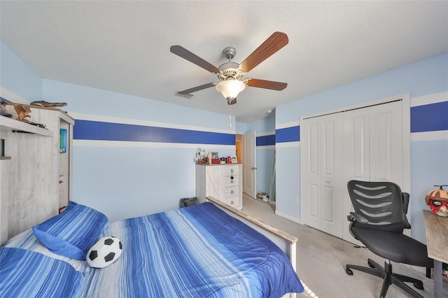 bedroom with ceiling fan, a textured ceiling, carpet flooring, visible vents, and a closet