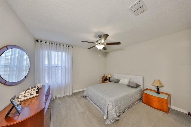 bedroom featuring baseboards, carpet, visible vents, and a textured ceiling