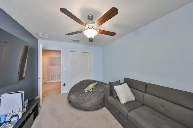 living room with visible vents, a textured ceiling, and light colored carpet