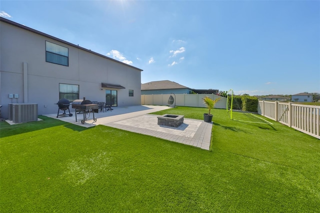 view of yard featuring an outdoor fire pit, central AC, a patio, and a fenced backyard