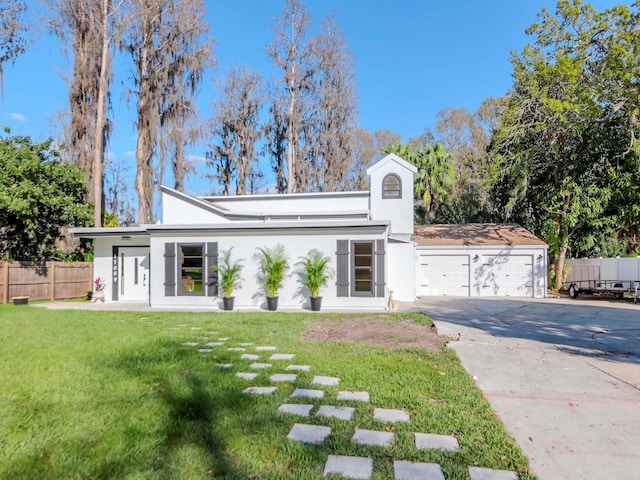 mid-century home with a garage, stucco siding, fence, and a front yard