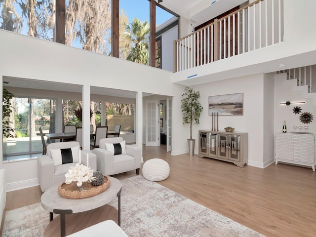 living area with baseboards, stairway, and wood finished floors