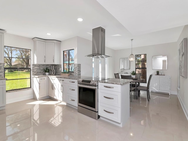 kitchen featuring island range hood, decorative backsplash, light stone counters, a peninsula, and stainless steel electric range