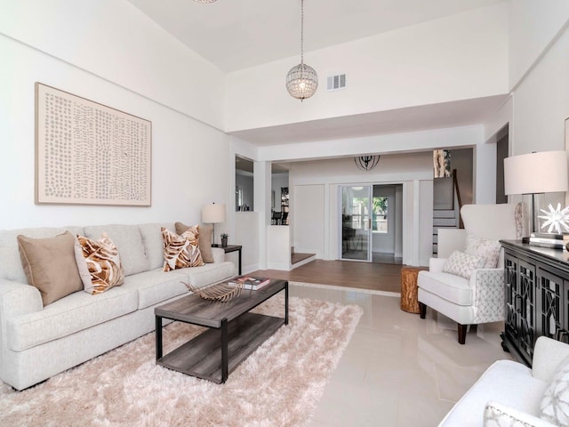 living area featuring a high ceiling, stairs, and visible vents