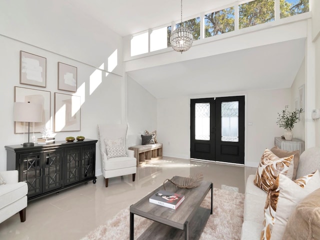 living area with a wealth of natural light, french doors, a high ceiling, and an inviting chandelier