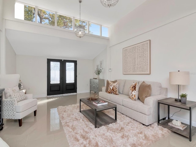 living area with a wealth of natural light, french doors, a notable chandelier, and a high ceiling