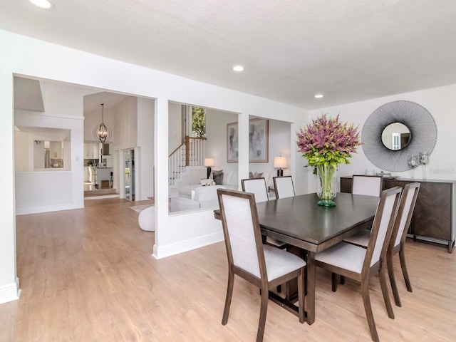 dining space with baseboards, stairway, light wood-style flooring, and recessed lighting